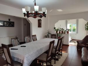 a dining room with a white table and chairs at Casa Danci Centru in Borşa