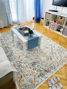 a living room with a white coffee table on a rug at Butterfly Apartment in Rijeka