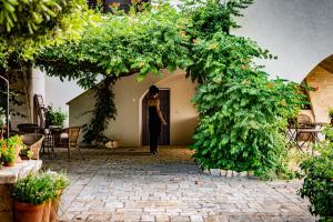 Una donna in piedi sulla porta di un palazzo di Antica Casina B&B di Charme a Pulsano