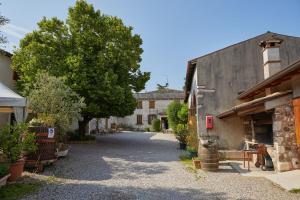 a street in a village with a building and a tree at Agriturismo Della Pieve in Bardolino