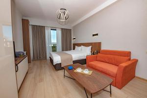 una camera d'albergo con un letto, un divano e un tavolo di Crystal Residence a Bakuriani