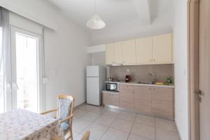 a kitchen with a table and a white refrigerator at Old Town Comfort by Irini in Kos