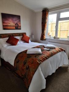 a bedroom with a large bed with red pillows at Captivatingly Stunning 2-Bed Cabin in Bridlington in Bridlington