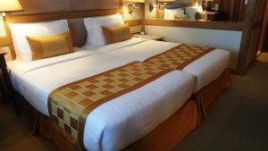 a hotel room with two large beds in it at Arnoma Hotel Bangkok - SHA Plus in Bangkok