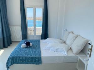 un letto bianco con un animale imbottito seduto sopra di Krios Luxury Suites a Krotiri