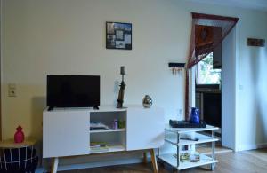 a living room with a tv on a white cabinet at Elbwald-Studio in Hitzacker