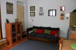 a living room with a black couch with red and green pillows at Apartman Brankova kuća in Sremski Karlovci