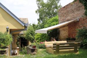 スレムスキ・カルロヴツィにあるApartman Brankova kućaのレンガ造りの建物の隣にベンチ付きの庭園