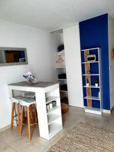 Habitación con escritorio blanco y pared azul. en studio presqu'île Fouras proche de la plage parking privé, en Fouras