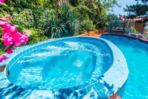 a large blue swimming pool with a tile floor and flowers at Guest House Irina in Loo