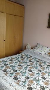 1 dormitorio con cama con colcha de flores en Pensiunea Irina, en Sîngeorz-Băi