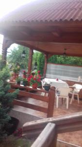 una terraza de madera con un pabellón con mesa y sillas en Pensiunea Irina, en Sîngeorz-Băi