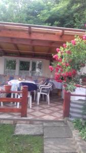 un patio con mesa, sillas y flores en Pensiunea Irina en Sîngeorz-Băi