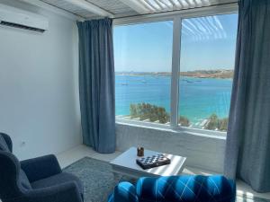 un soggiorno con una grande finestra con vista sull'oceano di Krios Luxury Suites a Krotiri