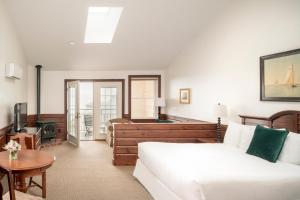 ein Wohnzimmer mit einem weißen Sofa und einer Badewanne in der Unterkunft Spruce Point Inn Resort and Spa in Boothbay Harbor