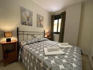 1 dormitorio con 1 cama con 2 toallas en Apartamento Playa Marina Particular Isla Canela, en Huelva