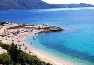 a group of people on a beach in the water at Laura Studio Apartman in Mlini
