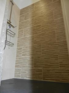 - un mur en pierre dans une salle de bains avec un mur en bois dans l'établissement L’ escapade, à Mallemort