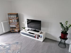 a white living room with a flat screen tv at Ferienwohnung Ratoldi in Radolfzell am Bodensee