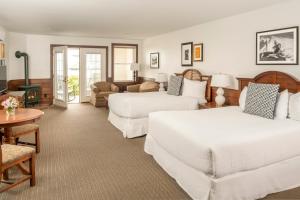 a hotel room with two beds and a living room at Spruce Point Inn Resort and Spa in Boothbay Harbor