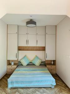 a bedroom with a large bed with white cabinets at Botanical Manor Apartment in Kaunas