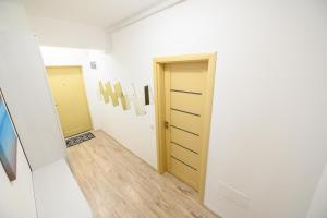 een hal met twee deuren en een houten vloer bij Sunset Lake Apartament Mamaia in Mamaia