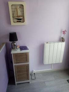 een kamer met een bureau en een plank met een zeil aan de muur bij Chez Gigi in Merville-Franceville-Plage