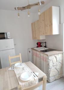 una cucina con tavolo e piatti di I love Ogliastra Apartments a Bari Sardo