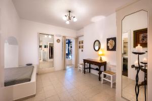 een kamer met een spiegel, een tafel en een bureau bij Moschatos Beach House in Kamari