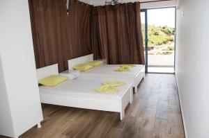 1 Schlafzimmer mit 2 Betten und gelben Kissen in der Unterkunft Heaven Beach Sarandë in Sarandë