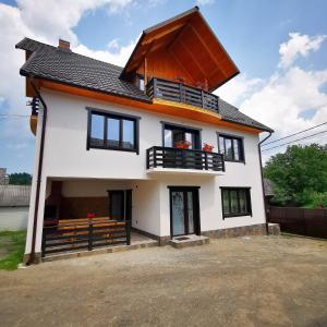 uma grande casa branca com um telhado de gambrel em Casa Petran em Breb