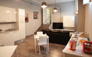 a kitchen and living room with a table and a couch at Casa Jomi b&b Borghetto Lodigiano in Borghetto Lodigiano