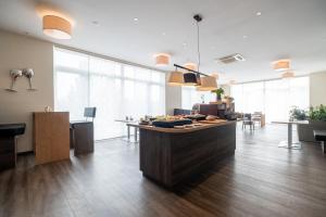 an office with a kitchen with a counter and tables at Amaro Hotel in Bergkirchen