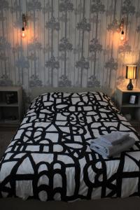 sypialnia z czarno-białym łóżkiem z lampką w obiekcie L'appartement d'Alexander w Troyes