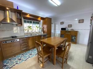 a kitchen with a wooden table and a dining room at Quinta Casal da Eva in Alcobaça