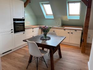 eine Küche mit einem Holztisch mit einer Vase mit Blumen darauf in der Unterkunft Rittergut Hirschbach - Verwalterhaus in Hirschbach