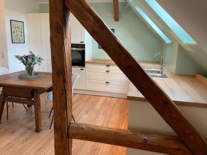 eine Küche mit einer Treppe mit einem Tisch und einem Waschbecken in der Unterkunft Rittergut Hirschbach - Verwalterhaus in Hirschbach
