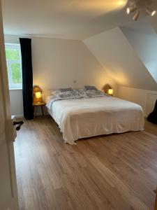 ein Schlafzimmer mit einem weißen Bett und zwei Lampen in der Unterkunft Rittergut Hirschbach - Verwalterhaus in Hirschbach