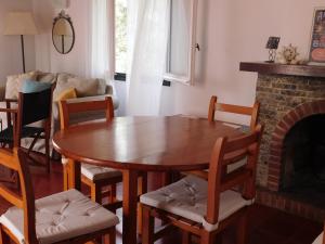 een woonkamer met een tafel en stoelen en een open haard bij Apart.Can Pons,con piscina, a 50 de la playa in Cala Galdana