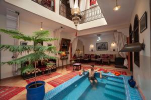 um homem parado numa piscina numa sala de estar em Riad De La Semaine em Marrakech