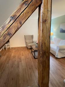 a living room with a couch and a wooden beam at Rittergut Hirschbach - Verwalterhaus in Hirschbach