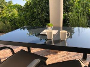 a glass table with two cups on top of it at Apartments Delfini in Sveti Filip i Jakov