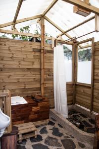 uma casa de banho com uma estrutura em madeira e um WC. em Yátaro Refugio Glamping em La Vega