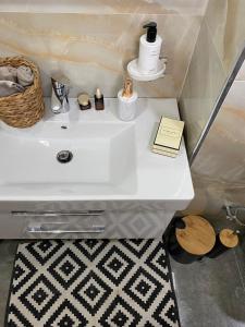a bathroom with a white sink with a book on it at Qerret Boutique Studio Apartment in Golem