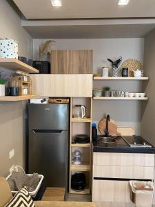 a small kitchen with a black refrigerator and shelves at Qerret Boutique Studio Apartment in Golem