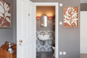 a bathroom with a sink and a toilet and a mirror at Central Apartment With Private Parking in Bath