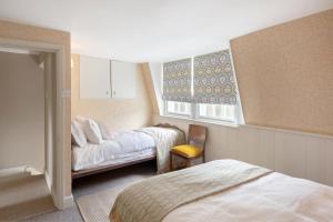1 dormitorio con 2 camas y ventana en Central Apartment With Private Parking en Bath