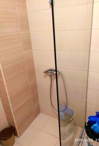 La salle de bains est pourvue d'une douche avec une porte en verre. dans l'établissement Your Comfy Apartment, à Saranda