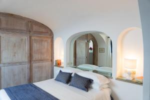 ein Schlafzimmer mit einem Bett und einem großen Spiegel in der Unterkunft Villa Castello Apartments in Capri