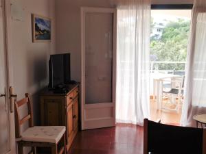 een woonkamer met een televisie op een dressoir met een schuifdeur bij Apart.Can Pons,con piscina, a 50 de la playa in Cala Galdana